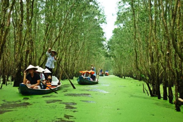 Boats carrying travellers along a canal in the Mekong Delta near Ho Chi Minh City